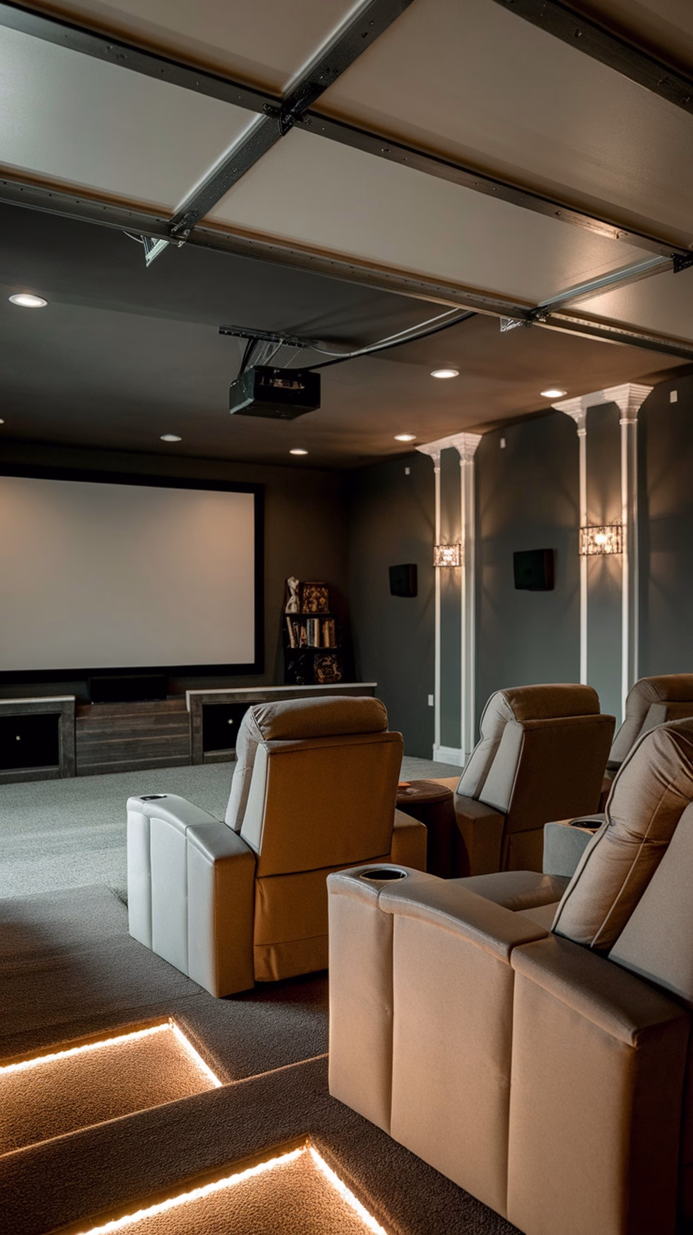 Cozy home theater setup in a garage with recliner seats, projector, and ambient lighting.