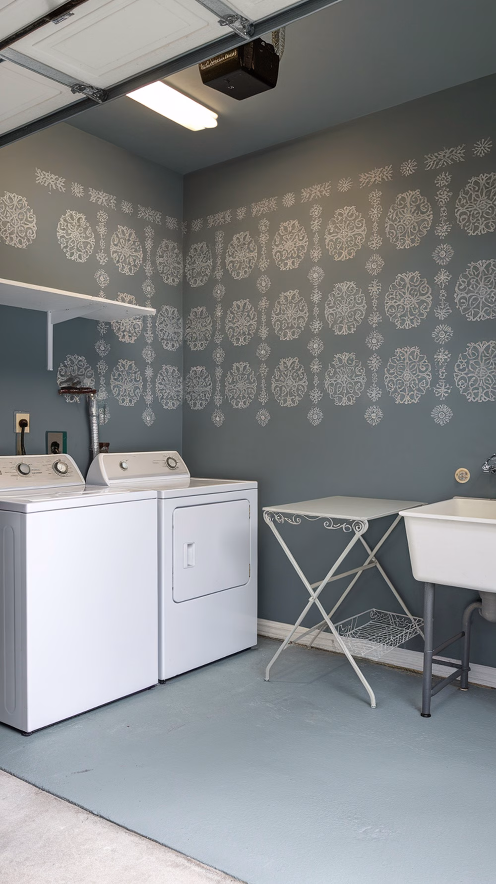 A garage laundry room with blue-gray walls and white stenciled patterns.