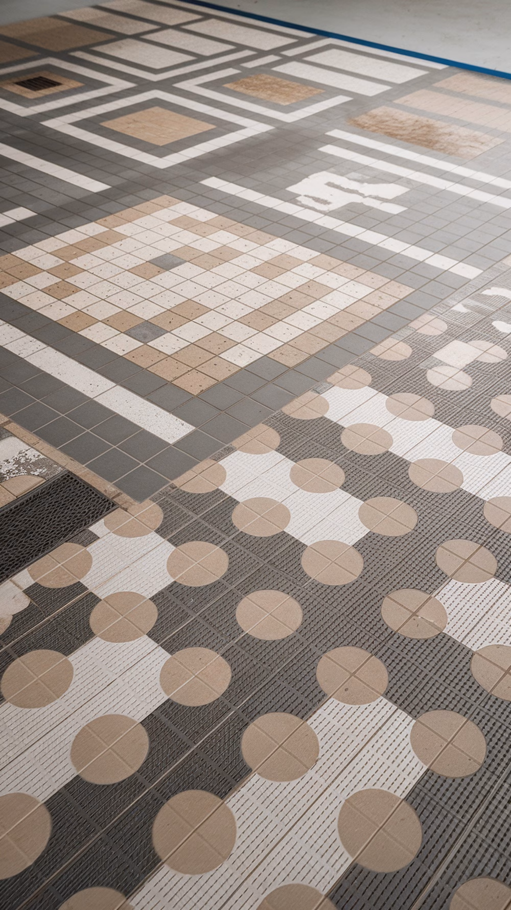A variety of tile patterns and colors on a garage floor, showcasing the versatility of tile flooring.
