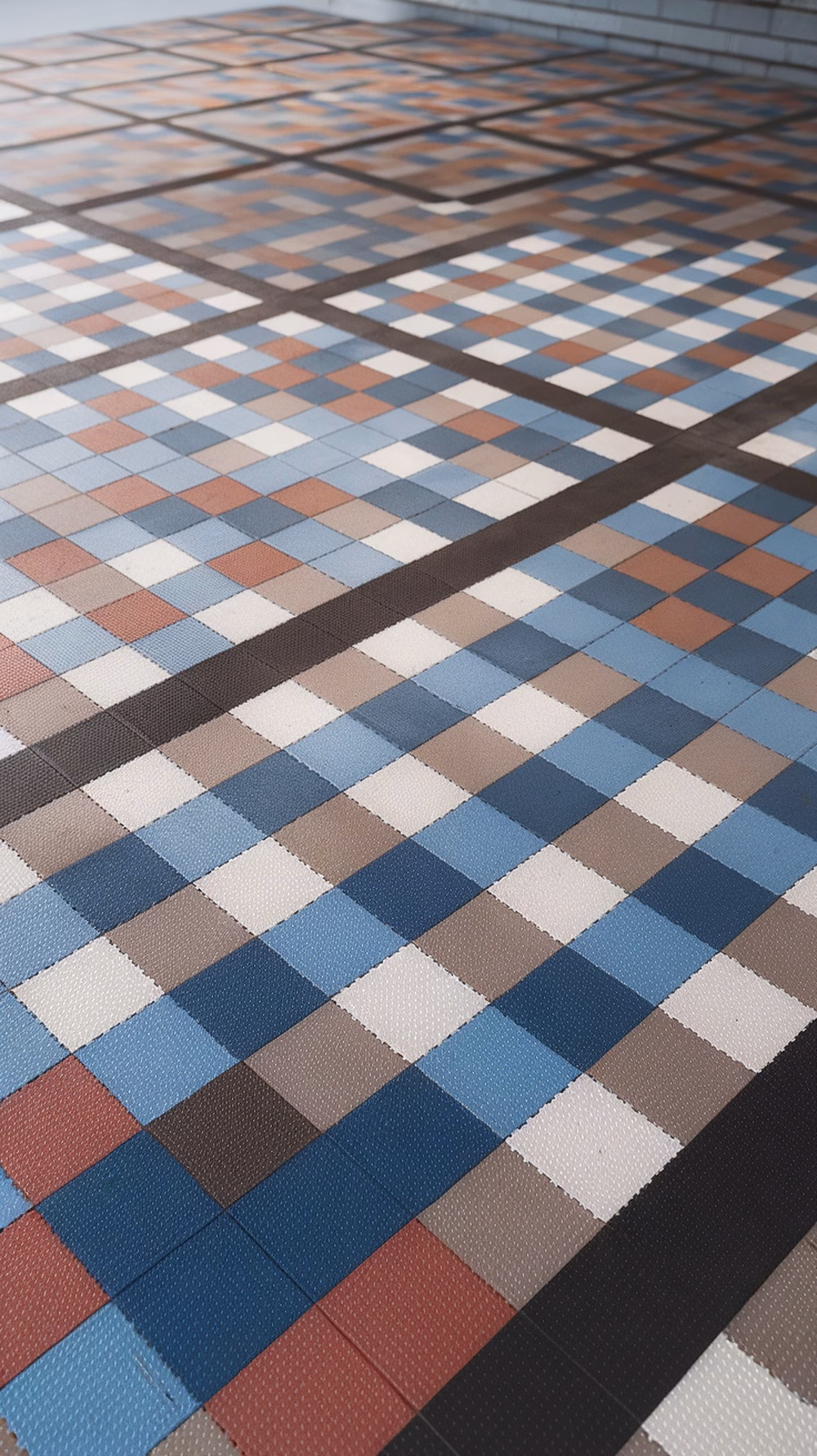 Colorful interlocking tiles arranged in a geometric pattern on a floor.